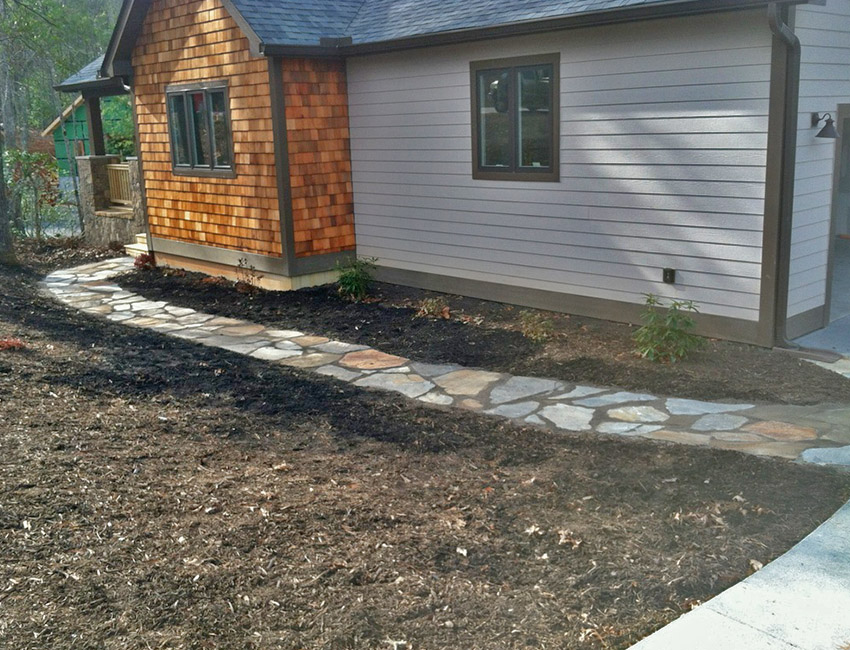 A stone walkway leading to a house.