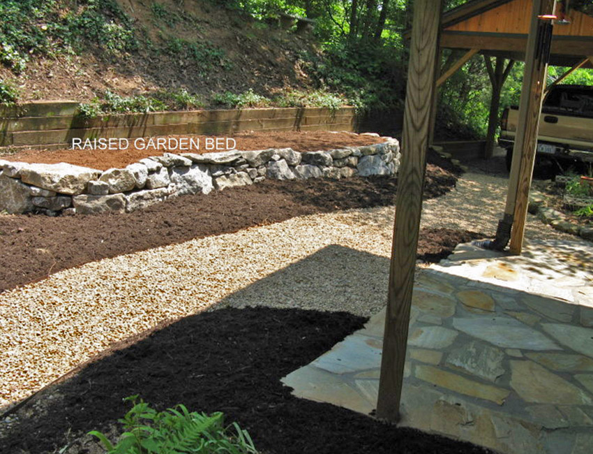 A backyard with a rock garden and a wooden bench.