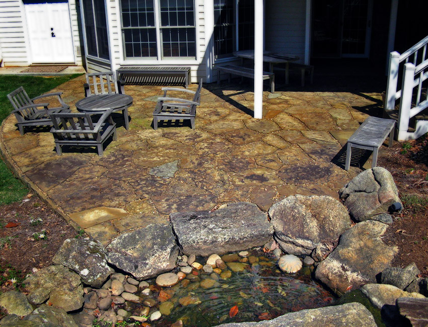 A stone patio with a pond.