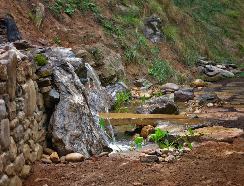 A small waterfall flowing down a hillside.