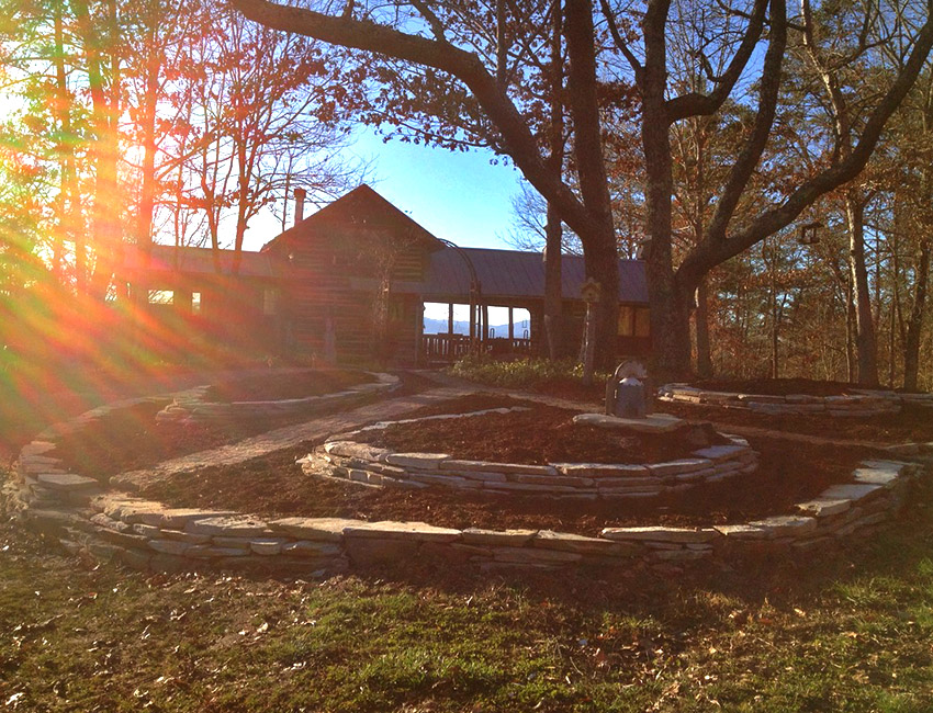 The sun is shining on a stone circle in front of a house.