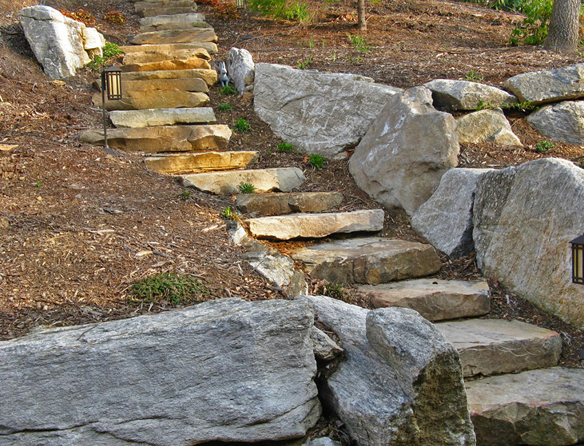 A set of stairs leading up to a stone wall.