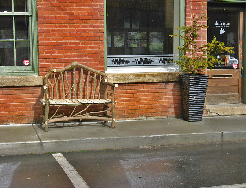 A bench in front of a brick building.